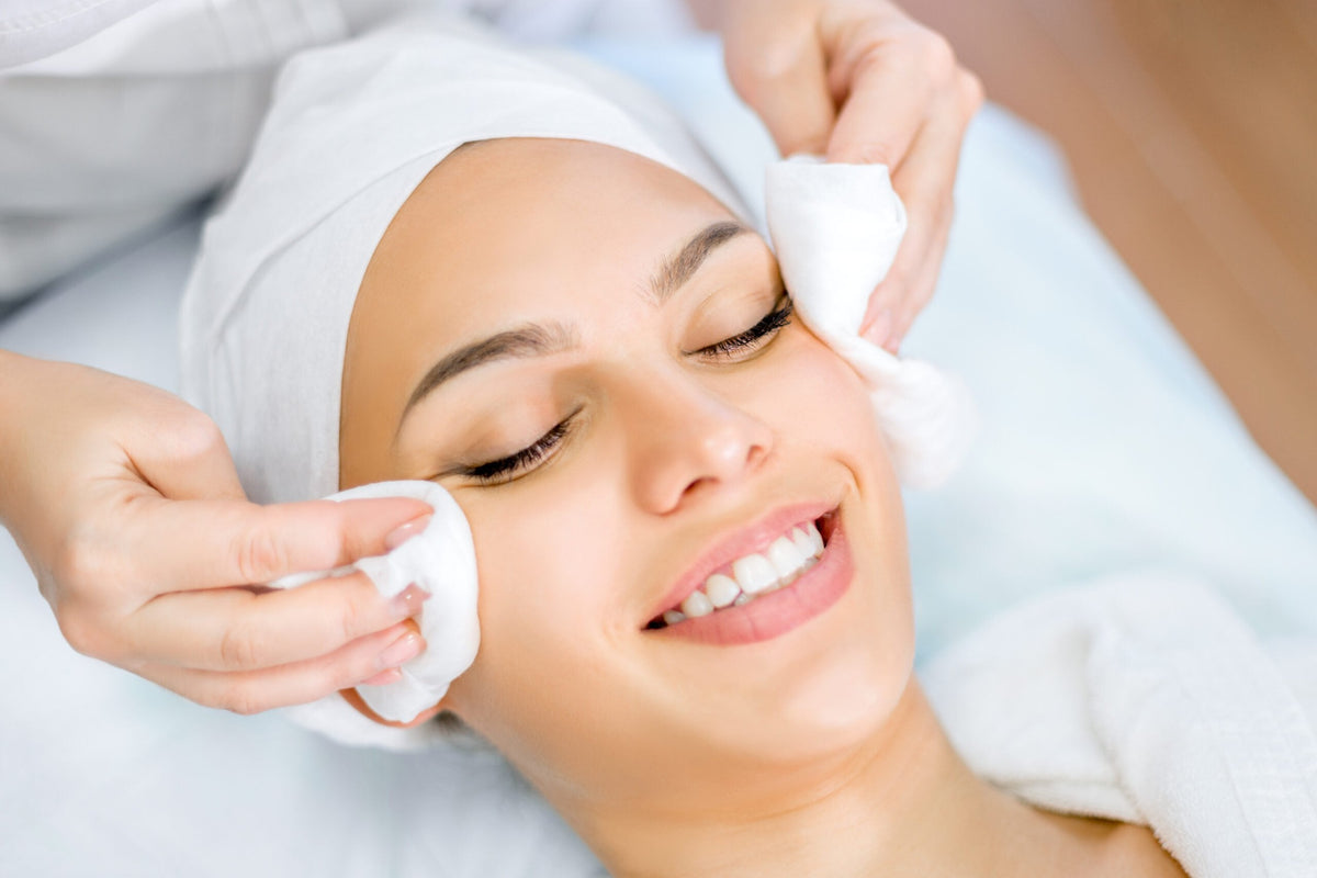 Client smiling during a professional facial cleansing treatment at Fusion Medispa in Tampa, FL